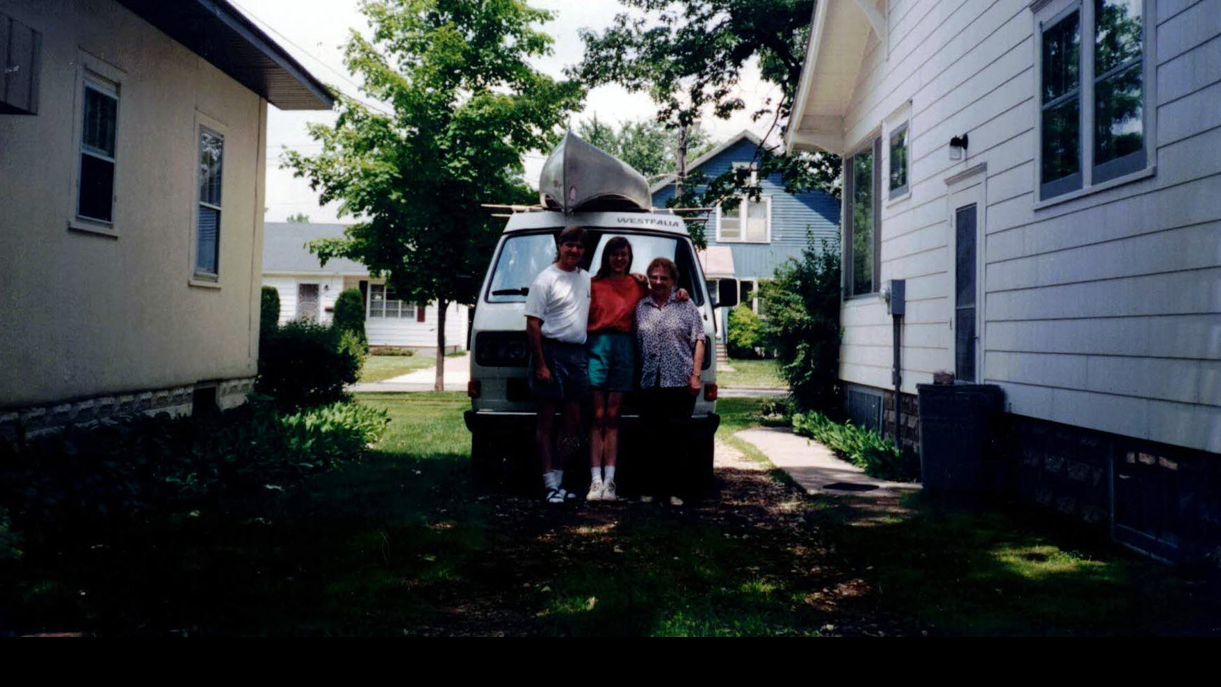 Jeff and Lisa Knight stand beside their Volkswagen Westfalia van with a canoe on top.