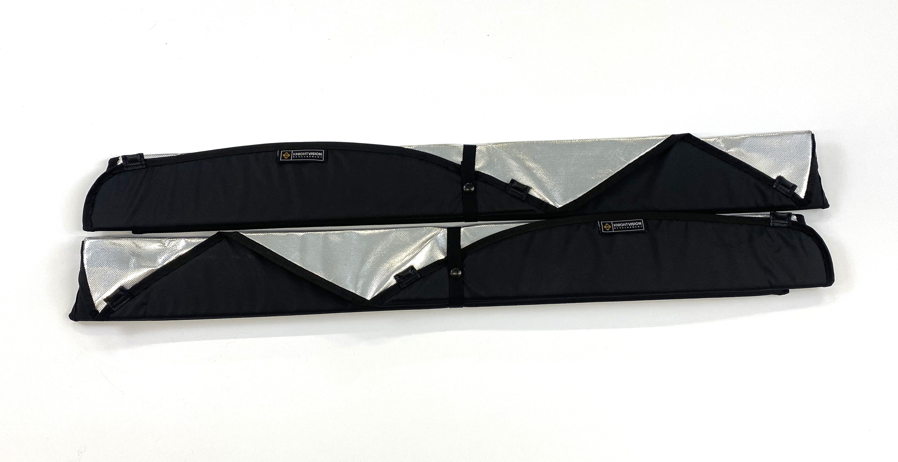 Two folded insulated van window covers with partial reflective interior showing and black exterior trim