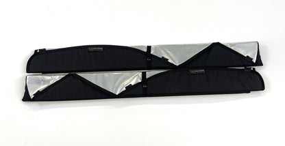 Two folded insulated van window covers with partial reflective interior showing and black exterior trim