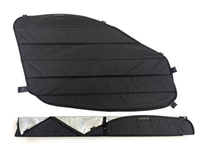 One unfolded black insulated window cover and one folded with reflective interior partially visible