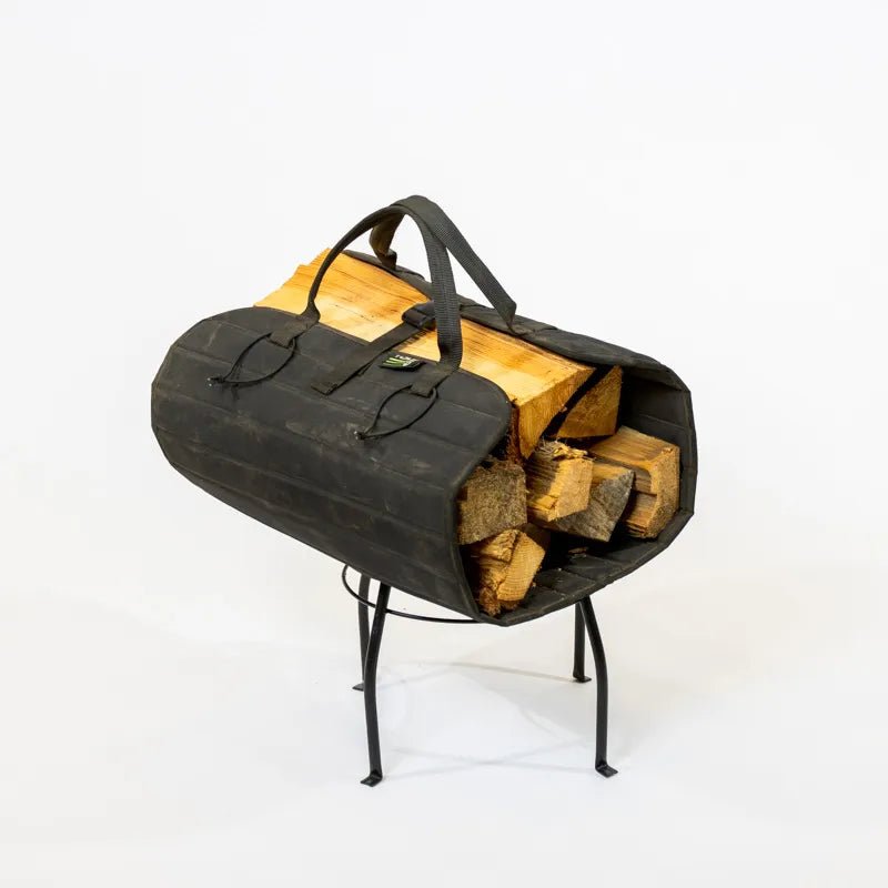 A black firewood roll with large carry handles, filled with firewood, designed to be carried and stored.